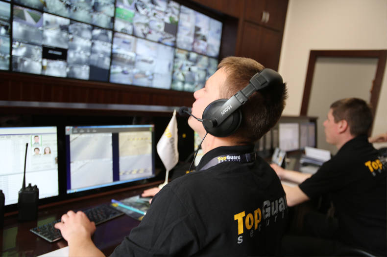 Охранник за пультом системы видеонаблюдения. Охранник за пультом системы видеонаблюдения.